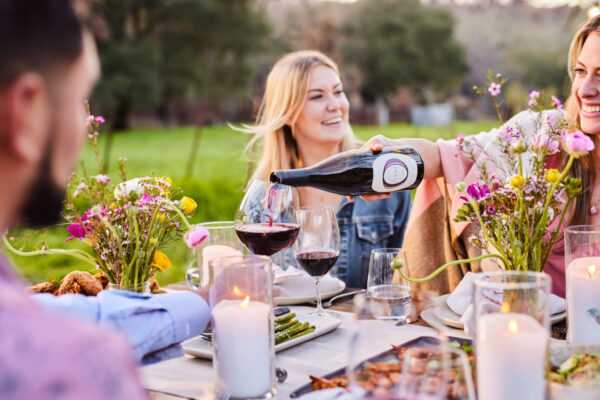 People enjoying Olema Pinot Noir at a dinner table outside